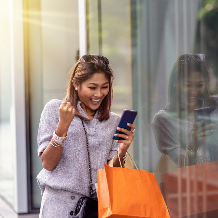 Woman shopping and excited about something on her phone