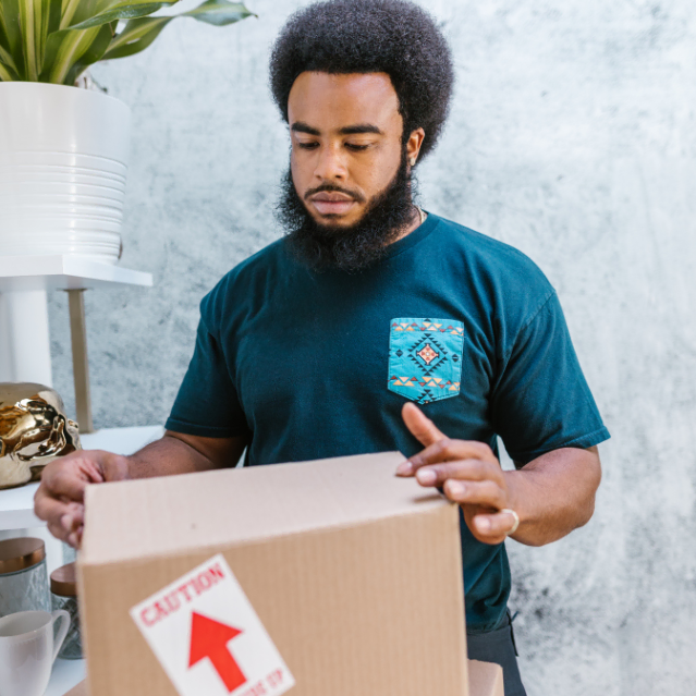 man closes a large brown cardboard box