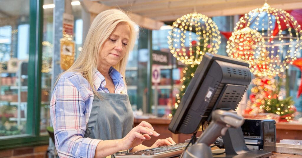 Woman at cash register processing returns and is concerned about holiday return abuse.
