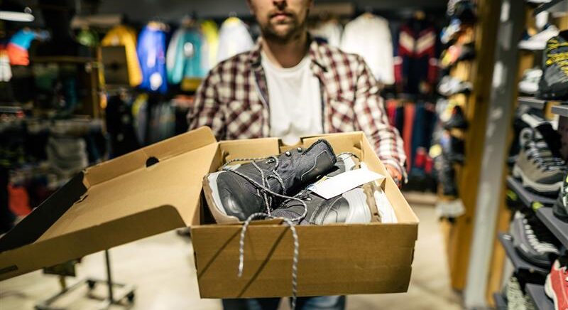 Man in an organized retail crime (ORC) group stealing footwear.