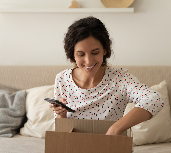 woman opening ecommerce purchase on couch appriss engage