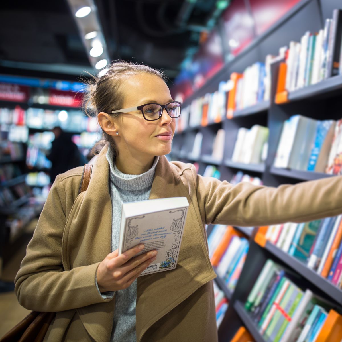 young-female-choosing-book-to-buy-in-a-bookstore